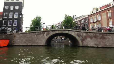 Boot-Blick-auf-den-legendären-Kanal-und-traditionelle-Brücke-in-Amsterdam,-Holland-Europa