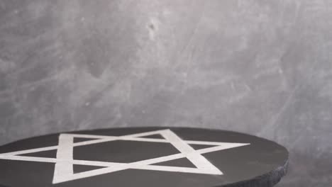 White-Star-of-David-on-a-black-stone-round,-rotation-360-degrees.