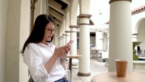 girl-bursting-into-laughter-while-texting-in-cafe