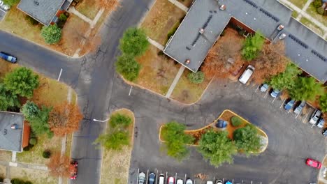 Toma-aérea-mirando-hacia-abajo-en-el-desarrollo-urbano-de-la-vivienda-de-amarillo-árboles-y-tejados