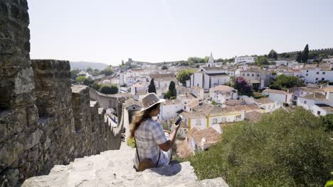 Woman-shooting-on-smartphone-and-sitting-on-steps