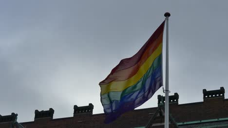 Regenbogenfahne-in-der-Innenstadt.-Regenbogenfahne-(LGBT-Bewegung)-flattert-im-Wind.-Nahaufnahme.