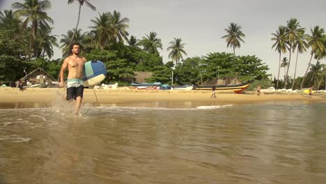 SLOW-MOTION:-Surfer-running-into-the-ocean-and-starts-paddling