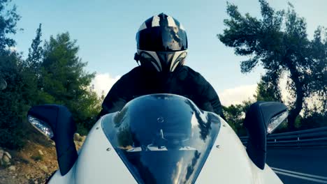 POv-shot-of-a-man-riding-on-a-white-sports-motorcycle-on-a-curved-road