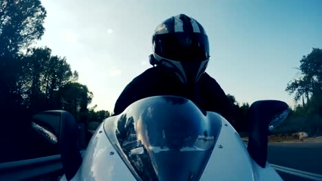 POv-shot-of-a-man-riding-on-a-white-sports-motorcycle-on-a-curved-road