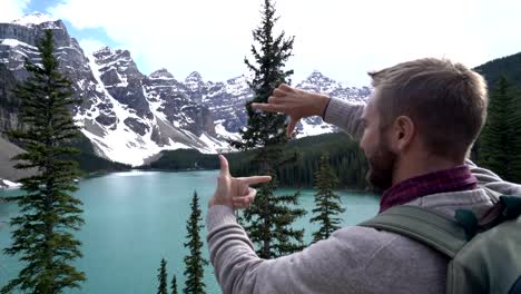 Un-joven-que-enmarcan-el-paisaje-de-montaña-con-las-manos