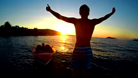 Reaching-The-Top,-crane-shoot,-winner-teen-hands-open-to-sunset-on-sea