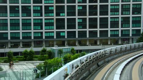 Moderne-High-Speed-Zug-vorbei-an-Wolkenkratzern-Olympische-Businesscenter-in-Tokio