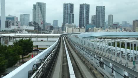 Modernas-de-alta-velocidad-tren-conduciendo-en-el-Centro-Olímpico-de-negocios-de-rascacielos-en-Tokio-Japón