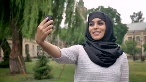 Joven-hermosa-mujer-musulmana-en-hiyab-está-haciendo-selfie-el-smartphone-en-tiempo-azul,-concepto-de-comunicación,-concepto-religioso