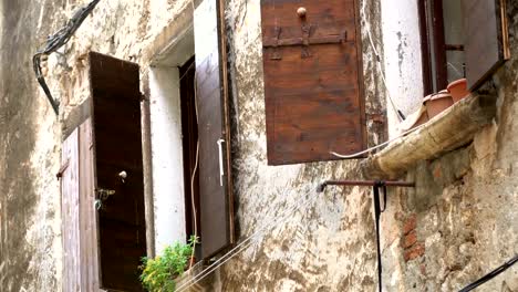 Una-vista-distante-de-la-pared-del-viejo-e-histórica-con-ventanas-y-persianas-en-el-sol-de-verano.