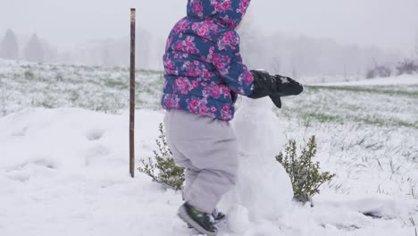Kleinkind-Schneemann-an-einem-verschneiten-Tag-berühren