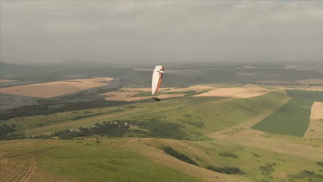 Athlet-Gleitschirm-fliegt-auf-seinem-Gleitschirm-neben-die-Schwalben.-Follow-up-Aufnahmen-aus-der-Drohne