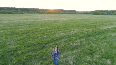 Frau-zu-Fuß-auf-dem-Feld-bei-Sonnenuntergang.