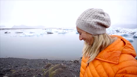 Mujer-de-turismo-joven-pisando-por-Laguna-glaciar-Jokulsarlon-playa