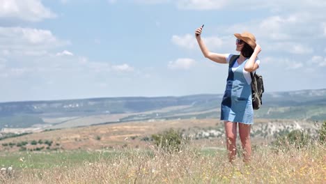 Aktive-Frau-Tourist-mit-Rucksack-nehmen-Selfie-im-Feld-mit-smartphone