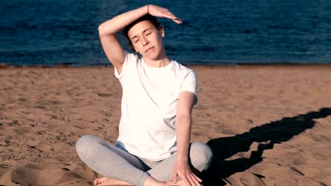 Frau,-dehnen,-Yoga-am-Strand-am-Fluss-in-der-Stadt.-Schöne-Aussicht.-Neigen-Sie-Kopf-zur-Seite.