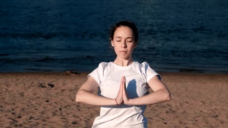 Mujer-de-estiramientos-yoga-en-la-playa-por-el-río-en-la-ciudad.-Vista-hermosa-ciudad.-Pose-de-Namaste.