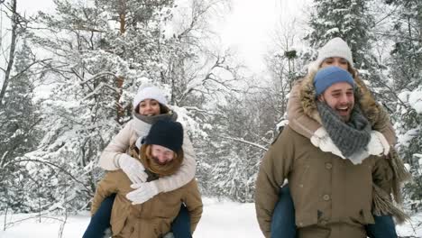 Junge-Paare-Huckepack-Reiten-im-verschneiten-Wald