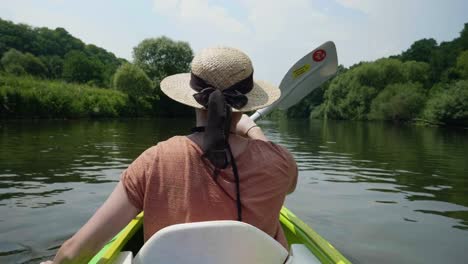 Chica-joven-canoa-en-un-lago-hermoso-y-sonriente-a-la-cámara-de