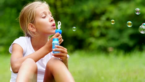 Little-girl-playing-with-soap-bubbles-outdoor.-Slow-motion.