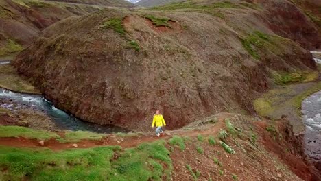 Amazing-drone-point-of-view-of-woman-hiking-on-mountain-ridge-over-canyon-in-Iceland.