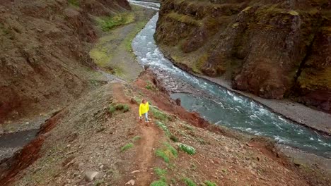 Erstaunliche-Drohne-Sicht-der-Frau-Wandern-auf-Bergrücken-über-Canyon-in-Island.