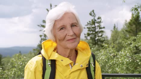 Positiven-Senior-Woman-Posing-auf-Sicht-in-Bergen