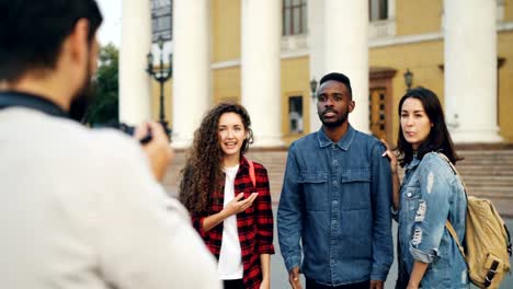 Multiethnische-Gruppe-von-ausländischen-Touristen-ist-die-Fotos-posiert-für-die-Kamera-und-Spaß-umarmen-und-lachen-stehen-in-schönen-Stadt-am-Sommertag.