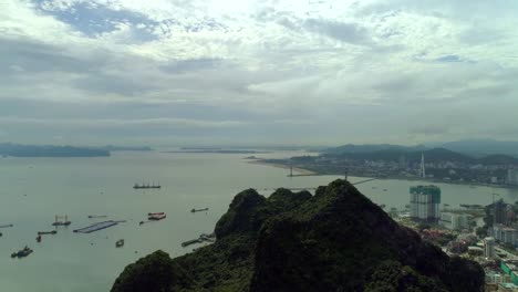 vista-aérea-4-k-sobre-la-ciudad-y-parque-con-Bai-Tho-montaña-del-karst-Ha-mucho-bay.-Ciudad-de-Halong.