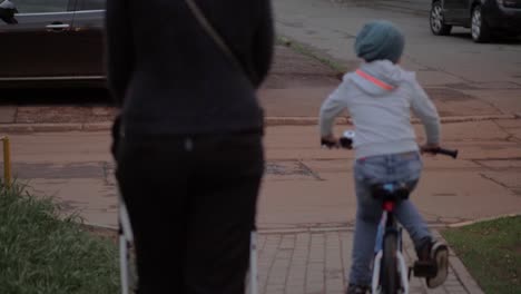 Mutter-mit-zwei-Kindern-auf-der-Straße.-Älterer-Junge-mit-dem-Fahrrad