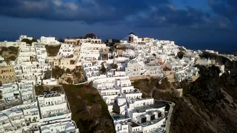 Flug-über-Dorf-Imerovigli-und-Skaros-Felsen-bei-Sonnenuntergang,-Santorin,-Griechenland