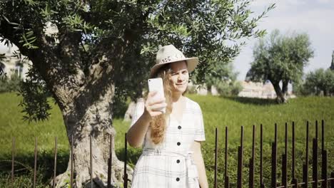 Woman-in-dress-taking-selfie-in-park