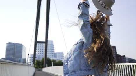 Smiling-woman-with-upping-hands-on-bridge