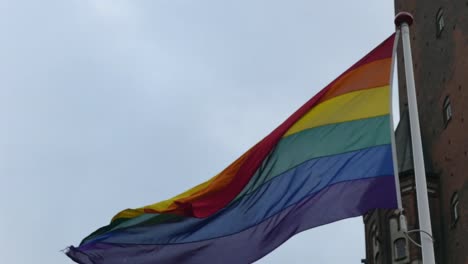 Regenbogenfahne-in-der-Innenstadt.-Regenbogenfahne-(LGBT-Bewegung)-flattert-im-Wind.-Nahaufnahme.
