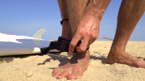 Surfer-strapping-a-leash-on-his-ankle