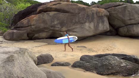 CÁMARA-LENTA:-Chica-surfista-caminando-por-el-agua