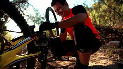 Mountain-biker-repairing-his-bike-on-a-trail