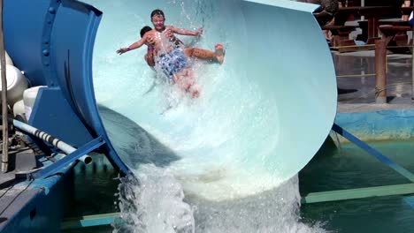 Slow-motion-of-2-happy-boys-sliding-on-water-slide,-Cape-Town,-South-Africa