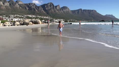 Young-boy-running-towards-the-camera-along-the-beach,South-Africa