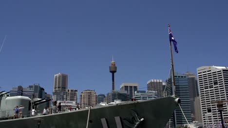 Frente-de-un-big-marine-ship-con-la-bandera-australiana-en-el-Sydney-tower-y-de-los-edificios-en-el-fondo