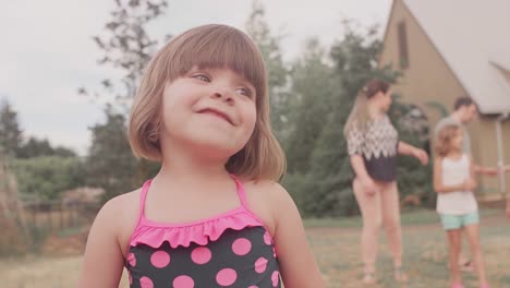 A-little-girl-walking-in-front-of-her-family-and-then-running-to-her-dad-who's-holding-a-flower