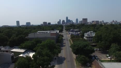 E.-Cesar-Chavez-St,-Aerial-view-of-street-car-traffic-with-buildings-in-background---Austin,-Texas,-USA