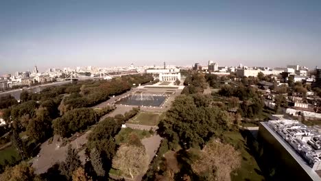 Aerial-view-of-Central-Moscow-Gorky-park.-Crowds-of-people-walking-over-central-park-in-Moscow,-Russia.-Moscow-river-bank,-park-full-of-green-trees-on-a-sunny-spring-day.