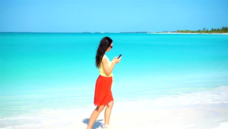 Young-woman-use-phone-during-tropical-beach-vacation.-Tourist-using-mobile-smartphone.