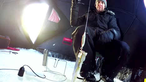 Ice-fisherman-fishing-in-tent