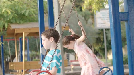 Kinder-schwingen-zusammen-auf-einem-öffentlichen-Spielplatz