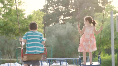 Kinder-schwingen-zusammen-auf-einem-öffentlichen-Spielplatz