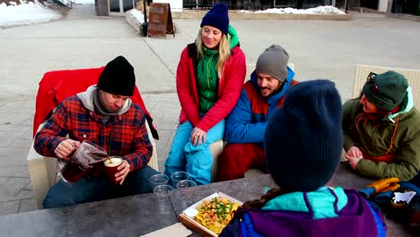 Friends-having-snacks-near-campfire