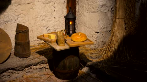 Pobre-habitación-en-una-casa-de-piedra-con-herramientas,-velas-y-alimentos